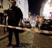 Un policía está detrás de un cordón bloqueando la calle cerca del sitio de un ataque en un restaurante en París. Se dice que hay 100 rehenes y al menos 47 muertos en tiroteos y explosiones en París. AFP