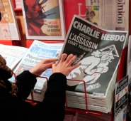 Una mujer mira a la edición especial conmemorativa del periódico satírico francés Charlie Hebdo en un quiosco en París, el 6 de enero de 2015, para conmemorar el primer aniversario del ataque yihadista que cobró la vida de 12 personas, entre ellas tres caricaturistas. AFP