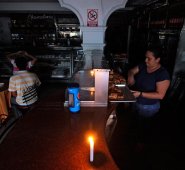 Los comerciantes venezolanos intentan mantener abiertos sus negocios a pesar del racionamiento energético. AFP