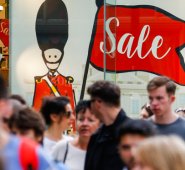 Los peatones caminan delante de una ilustración de un soldado de la Guardia de la Reina británica en el escaparate de una tienda en el centro de Londres. AFP