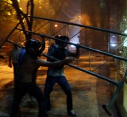 Manifestantes atacan con una barrera el edificio del Congreso durante enfrentamientos con la policía.  AP