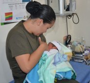 Alejandra Gutiérrez, en uniforme, alimenta a dos de los bebés refugiados en los albergues en Mocoa. Minutos antes estaba actuando como la policía que es. Cortesía