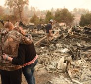 Kimberly Spainhower abraza a su hija Chloe, de 13 años, mientras que su esposo Ryan Spainhower busca entre las cenizas de su hogar quemado en Paradise, California. AFP