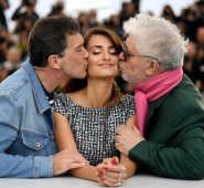 Almodóvar posó con traje verde y bufanda rosa, junto a Cruz, vestida con un vestido blanco y negro con pliegues en la falda, y Banderas, con cazadora y suéter de rayas azules y blancas. AFP