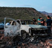 Miembros de la familia Lebaron observan el auto quemado donde parte de los nueve miembros asesinados de esta familia fueron asesinados y quemados durante una emboscada de hombres armados. AFP