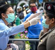 Funcionarios de salud, usando máscaras faciales en medio de temores sobre la propagación del nuevo coronavirus, controlan la temperatura corporal de las mujeres policías antes de una manifestación antigubernamental en Bangkok.
 AFP