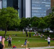 En Hong Kong la gente visita el Parque Tamar tras el anuncio de medidas para aliviar el confinamiento y el distanciamiento social. AFP
