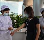 Un trabajador médico toma la temperatura de las personas que llegan al Hospital Tongji en Wuhan, provincia central de Hubei en China. AFP