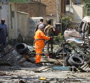 El personal de seguridad afgano (atrás) inspecciona el lugar de una explosión contra el convoy del vicepresidente de Afganistán, Amrullah Saleh. AFP
