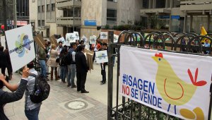 Varios manifestantes protestan afuera de Isagén exigiendo que no sea vendida. Colprensa