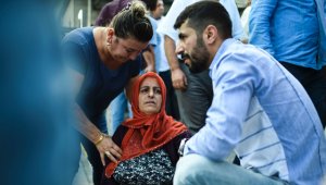 Dos personas acompañan a una mujer (centro) que perdió a un familiar, en las afueras del edificio de medicina forense cerca del aeropuerto de Estambul, un día después de un ataque suicida con bombas y armas. AFP