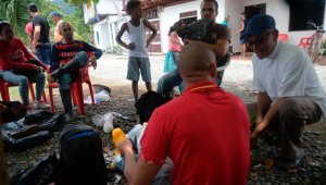 Reverendo Manuel Gregorio (derecha) habla con los inmigrantes cubanos que llegaron a Capurganá de Turbo, Colombia, mientras se preparan para cruzar ilegalmente a Panamá a través de la selva. AFP