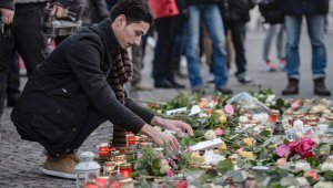 Un refugiado iraquí deposita una flor en un monumento improvisado cerca de la iglesia Kaiser-Wilhelm-Gedeechtniskirche (Iglesia conmemorativa Kaiser Wilhelm) en Berlín, cerca del sitio donde un camión se estrelló en un mercado de Navidad dos días antes, el 21 de diciembre. AFP