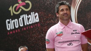 El actor estadounidense Patrick Dempsey rodó junto al pelotón en los kilómetros iniciales con una 'maglia' rosa 'vintage'. AFP