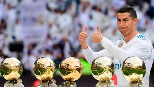 Cristiano Ronaldo lució sus cinco Balón de Oro en la grama del estadio madrileño. AFP