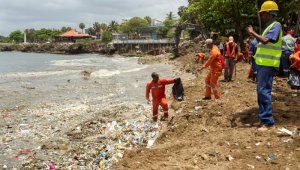 Funcionarios dominicanos limpian la costa de Santo Domingo tras una avalancha de basura arrastrada al paso de la tormenta Beryl. AFP