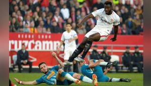 El defensa francés del Sevilla Joris Gnagnon (C) remata sobre la portería del Atlético de Madrid, en partido de la liga española. AFP