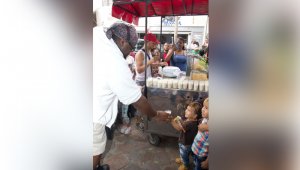 Spencer le da un vaso de avena a un niño, cerca al parque Mercedes Ábrego. Cortesía