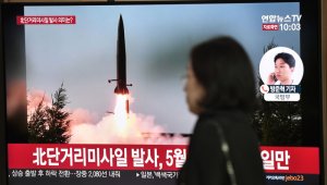 Una mujer pasa frente a una pantalla de noticias de televisión, que muestra imágenes de archivo de un lanzamiento de misiles de Corea del Norte, en una estación de tren en Seúl. AFP