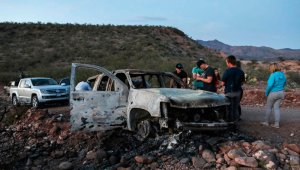 Miembros de la familia Lebaron observan el auto quemado donde parte de los nueve miembros asesinados de esta familia fueron asesinados y quemados durante una emboscada de hombres armados. AFP