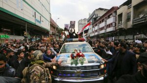 Los iraquíes rodean el coche que transporta los ataúdes del poderoso general iraní Qasem Soleimani y del hombre iraní en Irak, Abu Mehdi al Muhandis, muerto en una incursión estadounidense, en su funeral en el barrio de Kazimiya, Bagdad, el 4 de enero de 2020. AFP