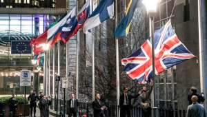 Los miembros del personal bajan la bandera del Reino Unido desde el exterior del edificio del Parlamento Europeo en Bruselas. Por su parte, en Gran Bretaña retiraron la bandera de la Unión Europea de todas sus instituciones.  AFP