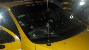Taxi con impactos de bala.  Cortesía