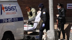 Trabajadores médicos traen a un paciente a un área especial para el coronavirus en el Centro Médico Maimonides, en Nueva York.  AFP