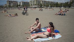 Las personas toman el sol en la playa de La Misericordia en Málaga, España. AFP