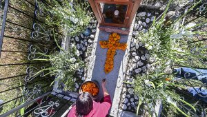 Una mujer decora la tumba de un familiar con caléndulas mexicanas formando una cruz en el Panteón La Magdalena, en San Pedro Cholula, estado de Puebla, México. AFP