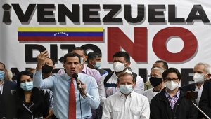 El líder opositor venezolano Juan Guaido hace gestos mientras habla durante una conferencia de prensa frente a un cartel que dice “Venezuela dijo no al fraude”, en el que anunció el lanzamiento de una consulta popular virtual para ignorar las últimas elecciones legislativas en Caracas. AFP