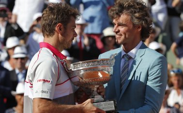 El suizo Stanislas Wawrinka, izquierda, recibe el trofeo de manos del brasileño Gustavo Kuerten, después de ganar final del torneo de tenis Abierto de Francia. AP