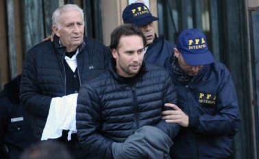 Padre e hijo fueron escoltados por la policía después de que se entregaron en una corte federal en Buenos Aires. AP