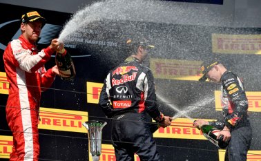 El piloto alemán de Ferrari, Sebastian Vettel, celebra junto al australiano Daniel Ricciardo y Daniil Kvyat, ambos de Red Bull Racing. AFP