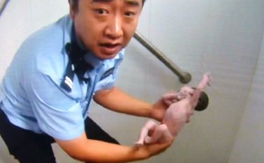 El policía con la bebé que rescató, en sus brazos. AFP