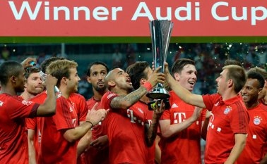 El centrocampista chileno Arturo Vidal y el defensa Philipp Lahm sostienen el trofeo de la Copa Audi. AFP
