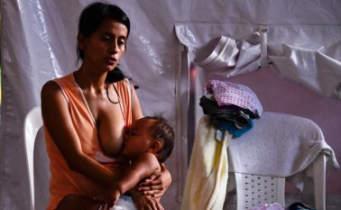 Una mujer amamanta a su bebé en un refugio de Cúcuta, después de haber sido deportado de Venezuela el 25 de agosto de 2015. AFP