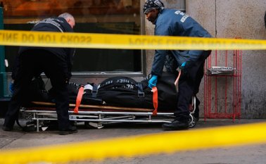Personal policial saca el cuerpo de la víctima de un andén del metro en la escena del tiroteo. AFP