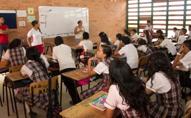 Los estudiantes de séptimo grado están atentos a la explicación de tratamiento de aguas residuales dada por una madre de familia. Luis
