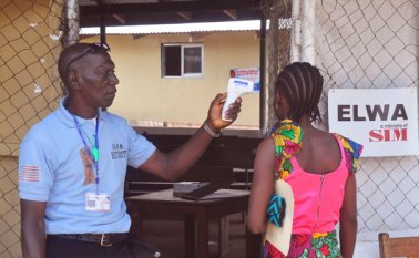 A un miembro de la familia no identificado del niño de 10 años que contrajo el ébola le mide su temperatura un trabajador de la salud antes de entrar en la clínica en donde el pequeño está siendo tratado. AP