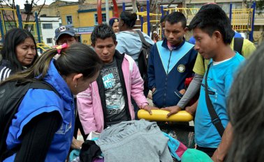 Nativos embera instalados en un parque en Bogotá reciben ropa usada donados por sus vecinos. Desde 2011, cuando una estampida de desplazamientos puso a más de un millar de Emberas a mendigar en las calles de Bogotá, la mayoría ha retornado a sus territorios, con dificultades. AFP