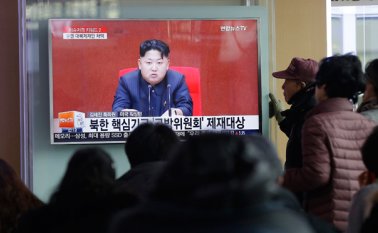 La gente ve un programa de noticias de televisión que muestra al líder norcoreano Kim Jong Un. AP