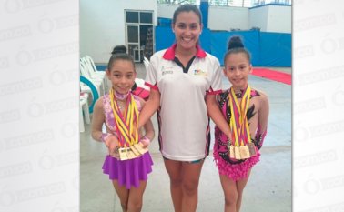 Las gimnastas Jeniffer Ibarra y Dana Zabala, acompañadas por la entrenadora Leidy Manrique, festejan la cosecha  de medallas obtenidas en el Nacional de gimnasia rítmica por niveles que se cumplió en Cali durante el fin de semana. Cortesía