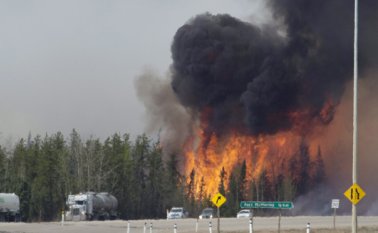 Las llamas parecen tragarse una caravana de vehículo que huyen a lo largo de la autopista 63 al sur de Fort McMurray (Alberta). AP