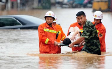 Rescatistas cargan a una mujer en camilla sobre una zona inundada en Jiujiang, en la provincia sureña de Jiangxi, China. AP