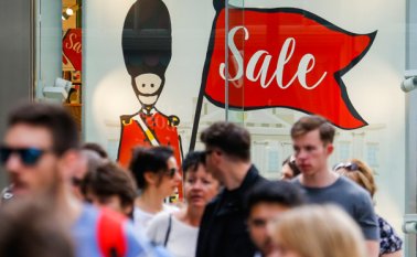 Los peatones caminan delante de una ilustración de un soldado de la Guardia de la Reina británica en el escaparate de una tienda en el centro de Londres. AFP