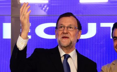 El presidente del PP y del gobierno español Mariano Rajoy saluda en una reunion de partidarios en presencia de la secretaria general María Dolores de Cospedal. AFP