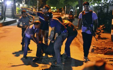 Un grupo de personas ayudan a un herido después que hombres armados atacaron un restaurante popular entre los extranjeros en una zona diplomática de Daca, la capital de Bangladesh, el viernes 1 de julio de 2016, donde tomaron rehenes e intercambiaron disparos con fuerzas de seguridad. AP