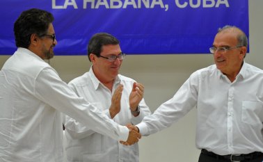 Humberto de la calle celebra con un apretón de manos con Iván Márquez. AFP