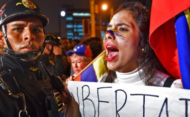 Maduro se trasladaba a pie por el sector Villa Rosa y los residentes de la zona salieron a protestar contra el mandatario, rodeándole mientras hacían sonar cacerolas. AFP